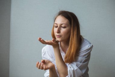 Bir kız, ellerinde kızıl uzun saçları olan bir kadın.