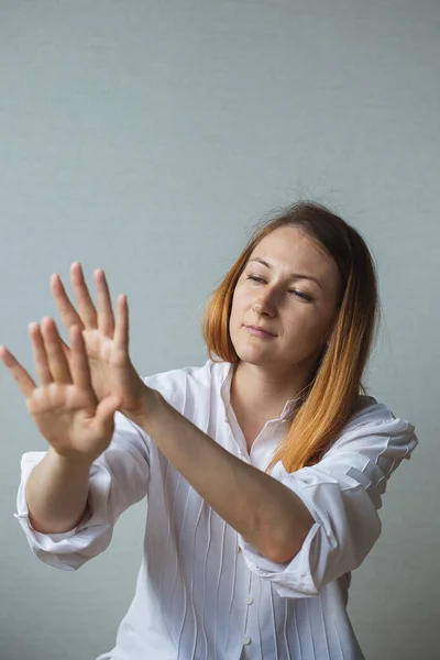Bir kız, kızıl uzun saçlı bir kadın ellerine bakar ve hayranlık duyar.