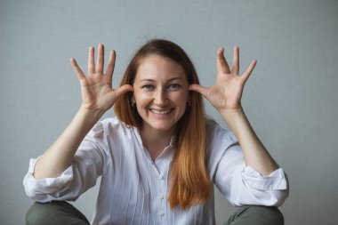 Bir kızın portresi, yüzler yapan, gülümseyen bir kadın