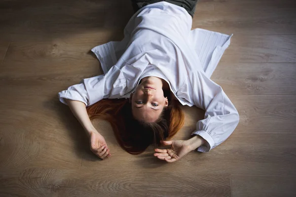 Bella giovane donna si trova sul pavimento e guarda lo spettatore — Foto Stock