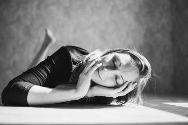 Genç bir kız yerde yatıyor.