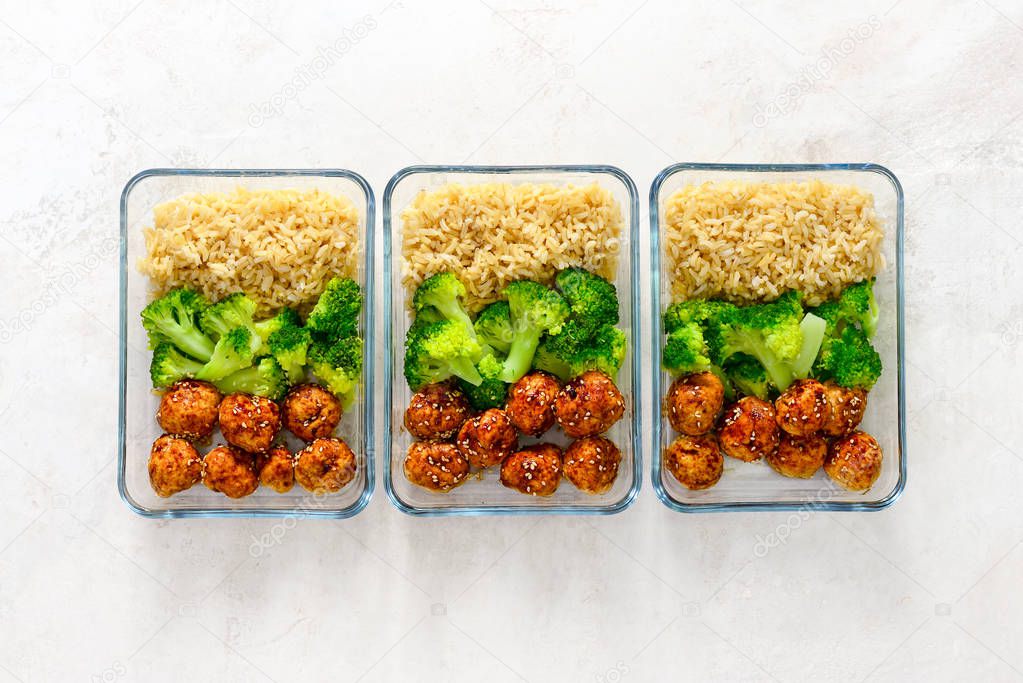 Asian style teriyaki sauce chicken meat balls with broccoli and rice prepared and put in a take away lunch boxes, view from above