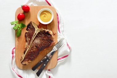 T-Bone biftek hissesini hizmet bir kesme tahtası, yukarıdan görünüm, bir metin için yer