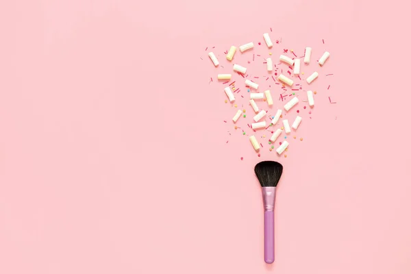 化妆的概念背景与一个空间的文本 化妆刷躺在一个柔和的粉红色表面和棉花糖和糖果糖果溅出的刷子 — 图库照片