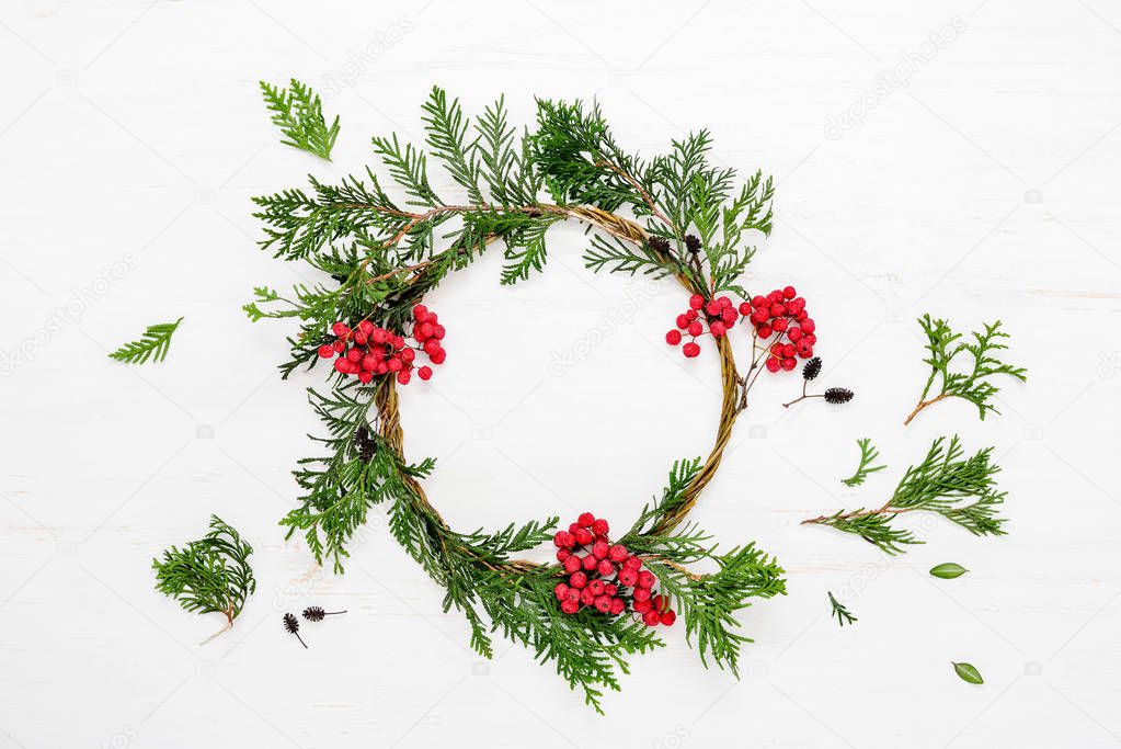 Noel or Christmas background with handmade Xmas wreath decorated with red berries, view from above, space for a text