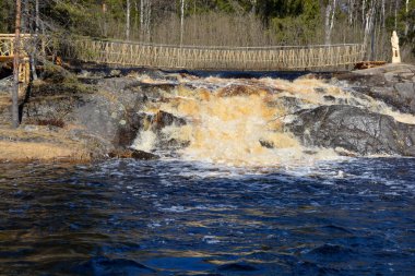 Rusya 'nın kuzey ormanlarında kaynayan bir nehir. Köprüden bir bakış. Güneşli bir gün, bulutlar.