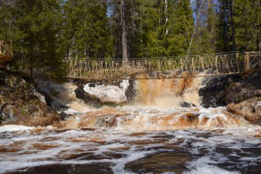 Rusya 'nın kuzey ormanlarında kaynayan bir nehir. Köprüden bir bakış. Güneşli bir gün, bulutlar.