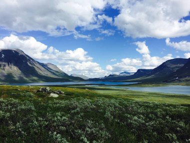 Kuzey İsveç 'te Kungsleden yürüyüş yolu boyunca Alesjaurestugorna yakınlarında dağlarla çevrili güzel bir göl.