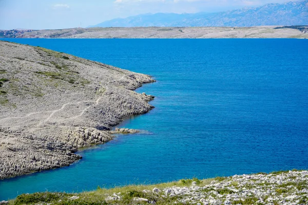 Rocks on the shore of the blue sea. Rocks and blue water. Cliff near the sea. Grey and blue in nature.