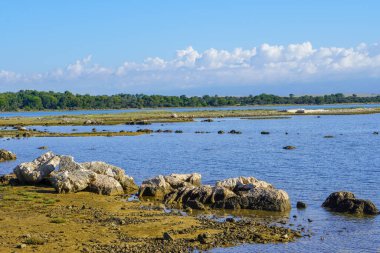 Gün batımında dalgalı denizde taş