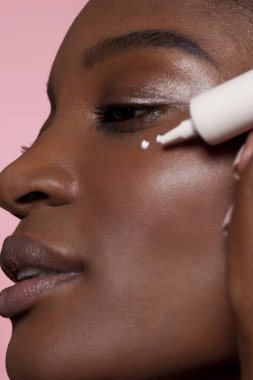 Genç kadın göz kremi uygulama