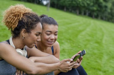 Two female friends using phones