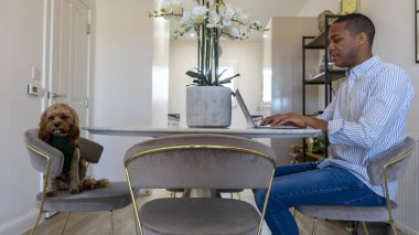 Man and dog sitting at dining table