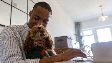 Man with dog sitting at table
