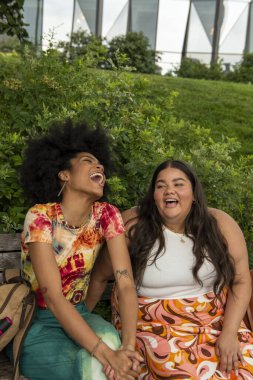 Two young women sitting on bench