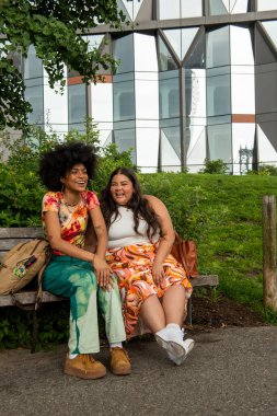 Two young women sitting on bench