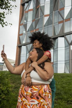 Two young women taking selfie in urban setting