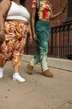 Two women on sidewalk, low section