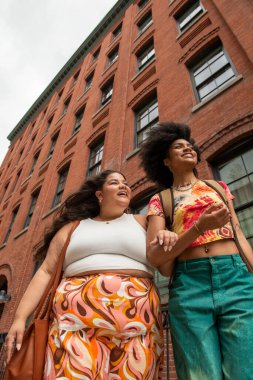 Tuğla binanın önünde iki kadın, düşük açılı.