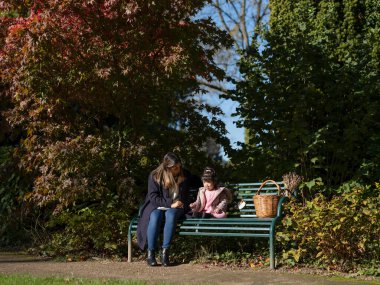 Mother and daughter with Down syndrome sitting on bench