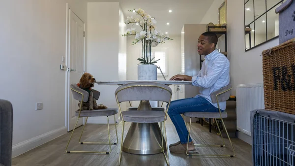 Man and dog sitting at dining table