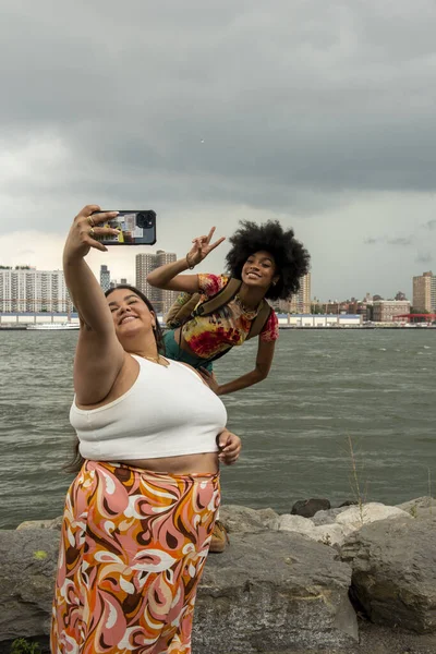 ABD, New York City, Nehir kenarında fotoğraf çeken iki kadın