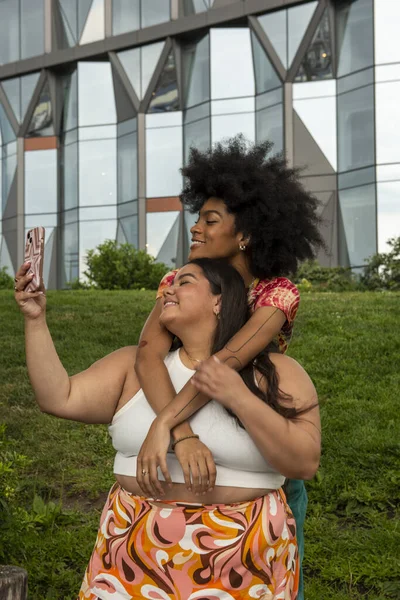 Two young women taking selfie in urban setting