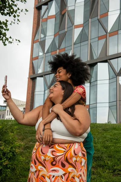 Two young women taking selfie in urban setting