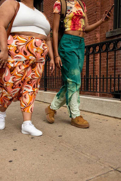 Two women on sidewalk, low section