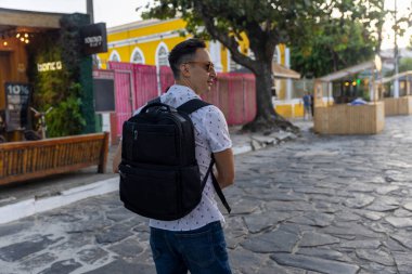 Rear view of man with backpack in old town