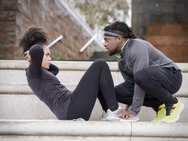 Erkek, dışarıda mekik çeken bir kadına yardım ediyor.