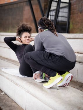 Erkek, dışarıda mekik çeken bir kadına yardım ediyor.