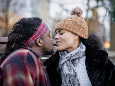 Couple kissing outdoors, close up portrait