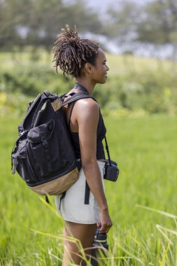 Indonesia, Bali, Side view of female tourist standing in field