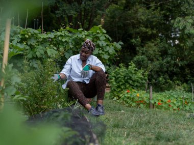 Bahçe işlerinde çalışan olgun bir kadın.
