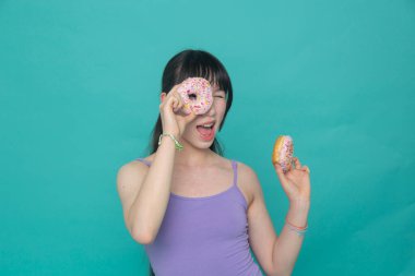 Stüdyo portresi, elinde donut tutan neşeli bir kız.