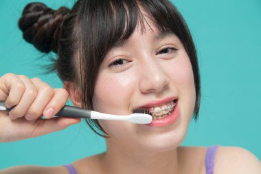 Gülümseyen dişlerini fırçalayan kızın yakın çekimi.