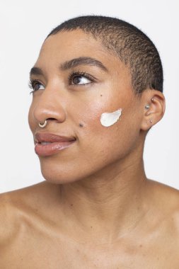 Studio portrait of woman with face cream on cheek