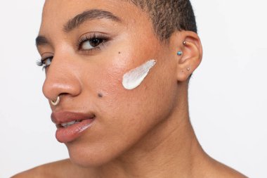 Studio portrait of woman face cream on cheek