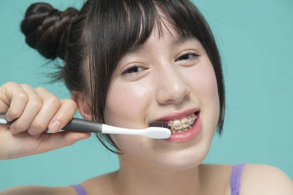 Gülümseyen dişlerini fırçalayan kızın yakın çekimi.