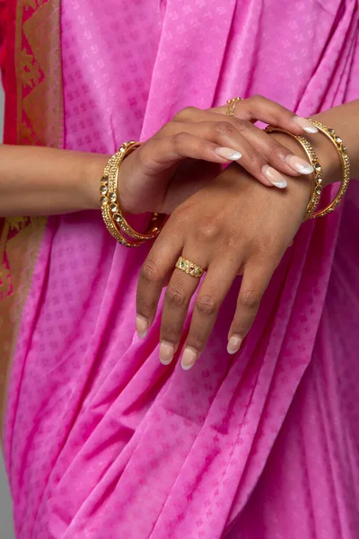 Sari ve altın takı takan bir kadının orta bölümü.