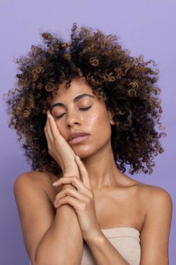 Portrait of brunette woman with eyes closed, touching face