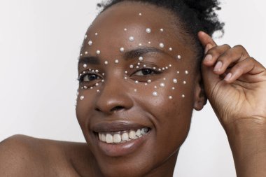 Smiling young woman wearing pearl freckles