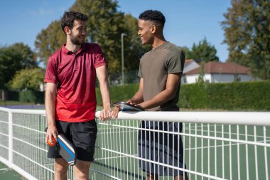 Pickleball sahasında gülümseyen adamlar