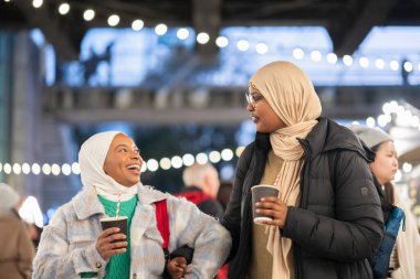 Sıcak kakao içen genç kadın turistler