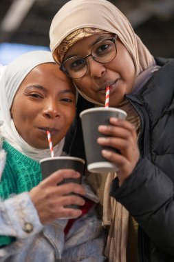 Sıcak kakao içen genç kadın turistlerin portresi.