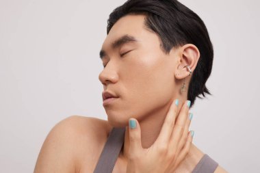 Kulak delen yakışıklı bir adamın stüdyo portresi