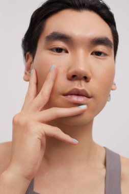 Renkli tırnaklı yakışıklı bir adamın stüdyo portresi.