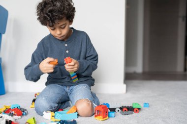 Boy (6-7) playing with toy blocks at home
