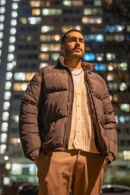 Genç adam geceleri dışarıda duruyor.